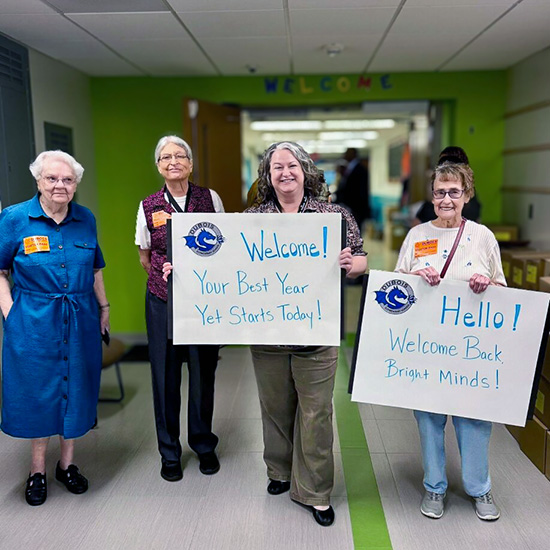 Senior residents hold up encouraging signs during a trip to a local school.